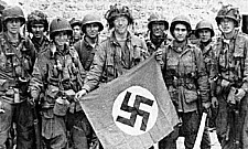 Leden van het 508th PIR met een buitgemaakte swastika vlag.
